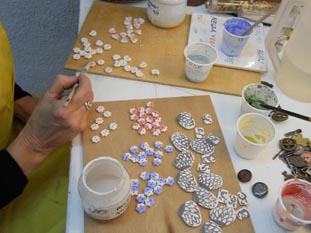 Tallers Oberts pintant botons al taller